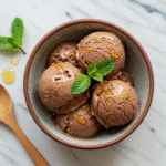 Cottage cheese chocolate ice cream served in ceramic bowl with mint garnish