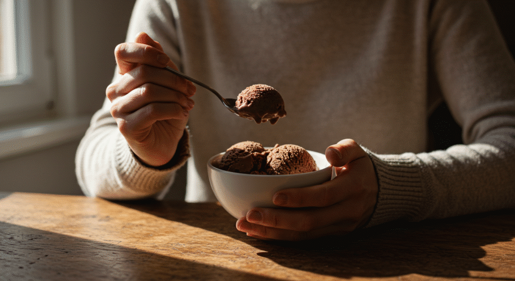 Hands holding spoon and bowl of homemade cottage cheese chocolate ice cream