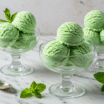 Cottage cheese mint ice cream scoops in glass bowls with fresh mint garnish
